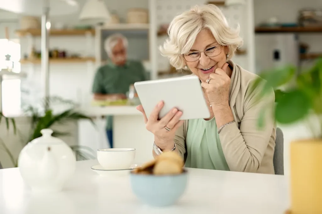Mujer mayor consultando una página web en una tablet en su casa